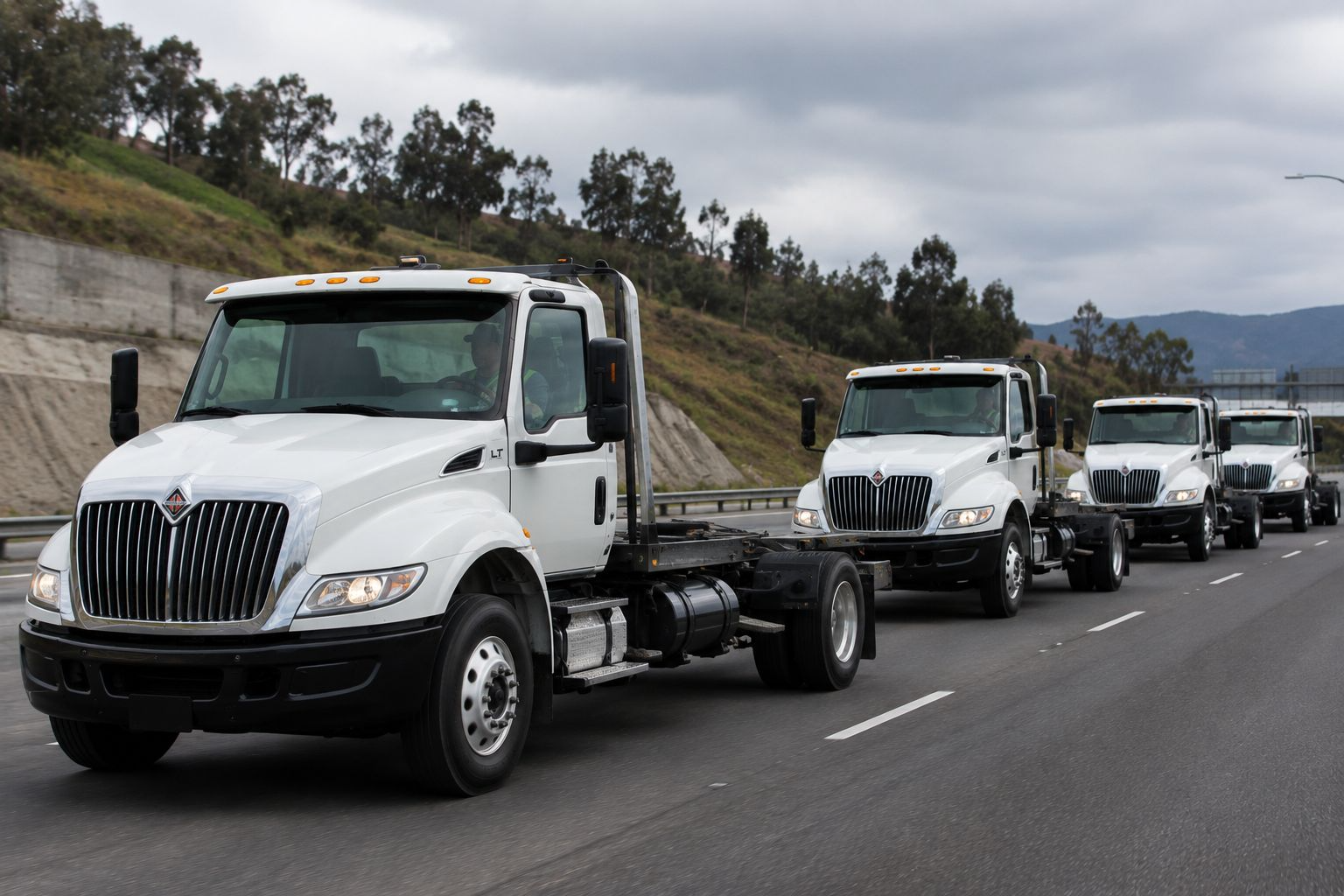 Convoy de camiones blancos de Grupo 81 trasladándose por carretera